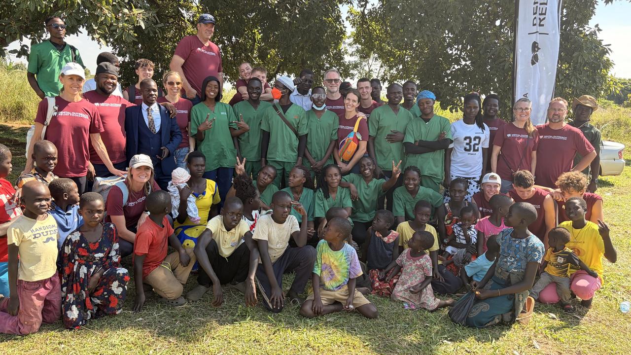 Ugandan dental students, visiting clinicians and children from the community gathered together after a YKMI outreach day